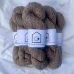 Skeins of brown yarn with labels on a white background